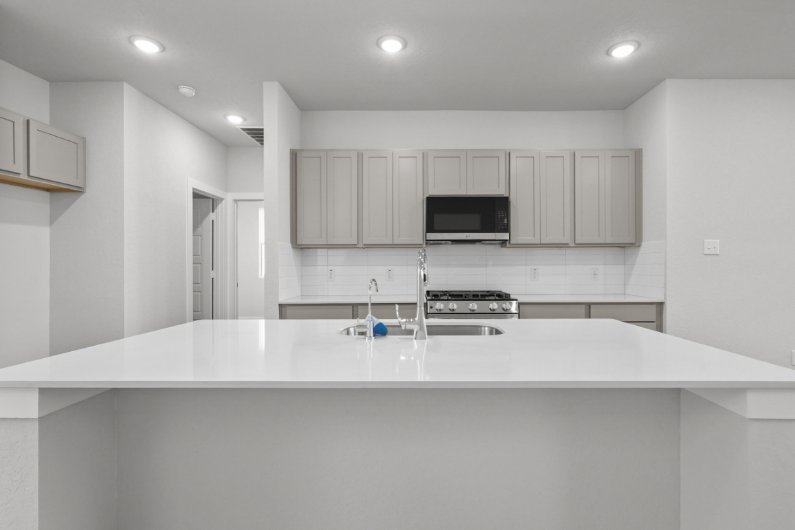 A kitchen with white cabinets.