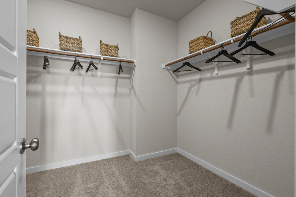 A white bathtub with a chair and a table with baskets on it.