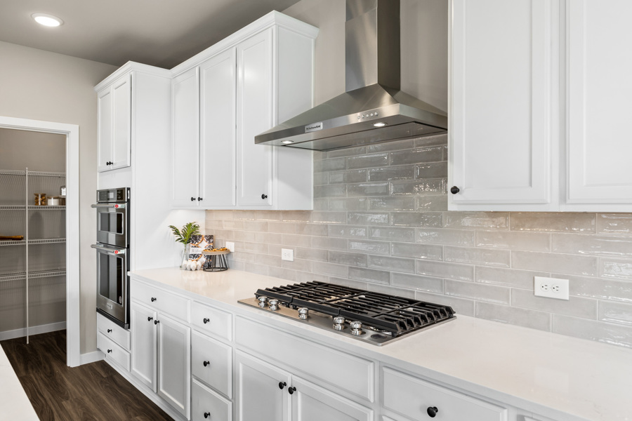 A kitchen with white cabinets.