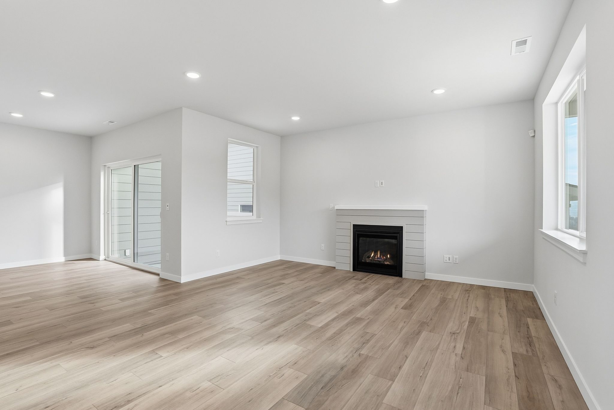 A room with a fireplace and wood floors.