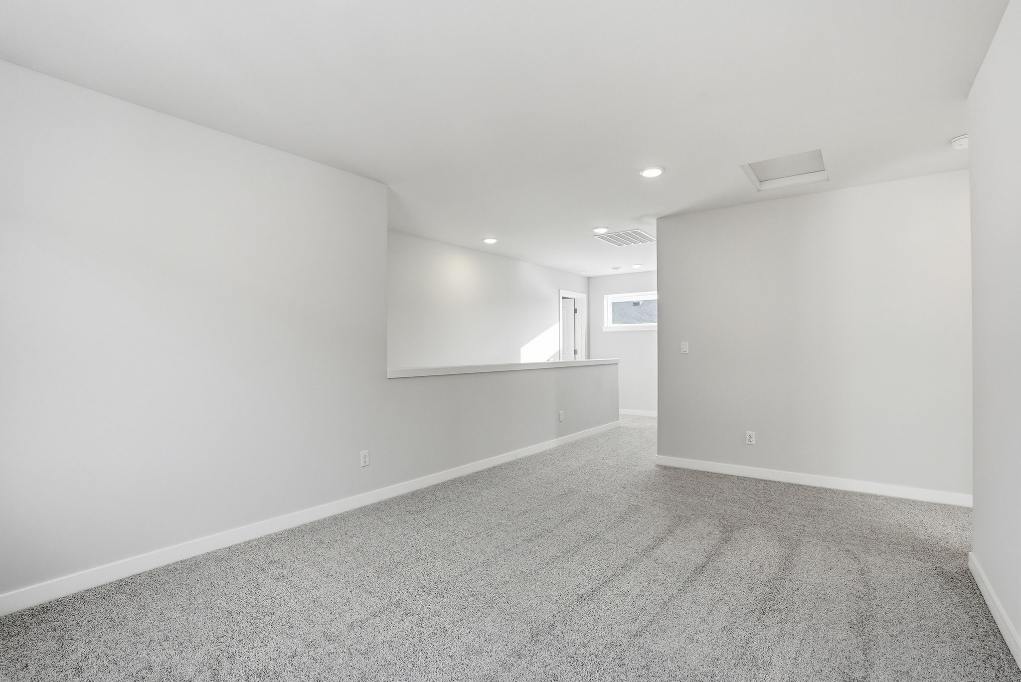 A room with a carpet and a white wall.