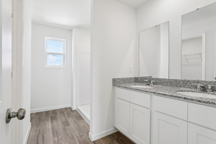 A bathroom with white cabinets.