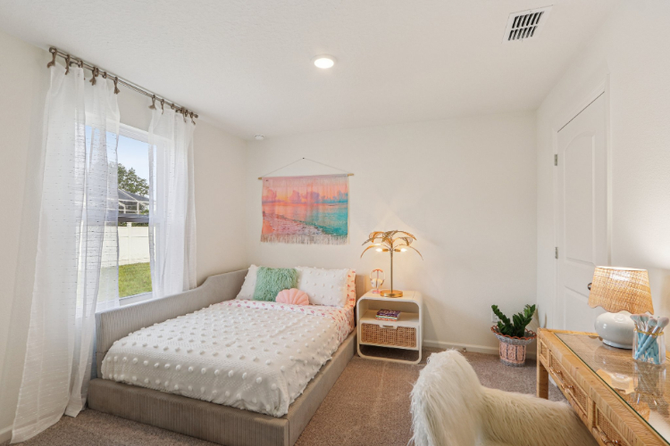 A bedroom with a bed and a table.