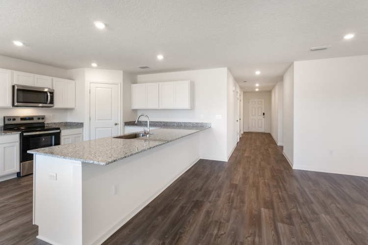 A kitchen with white cabinets.