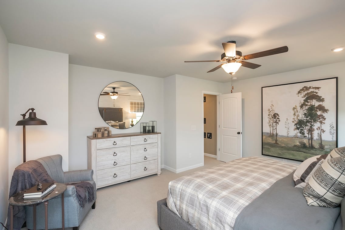 A bedroom with a large mirror.