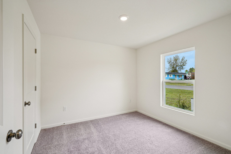 A room with a window and a carpet.