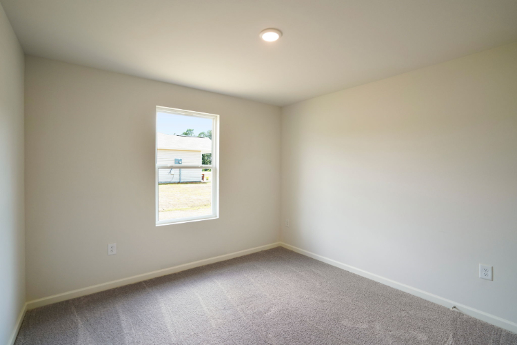 A room with a window and a carpet.