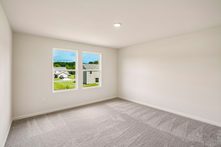 A room with a window and a green field.