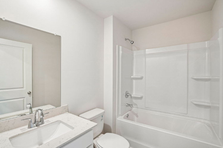 A bathroom with a tub sink and toilet.