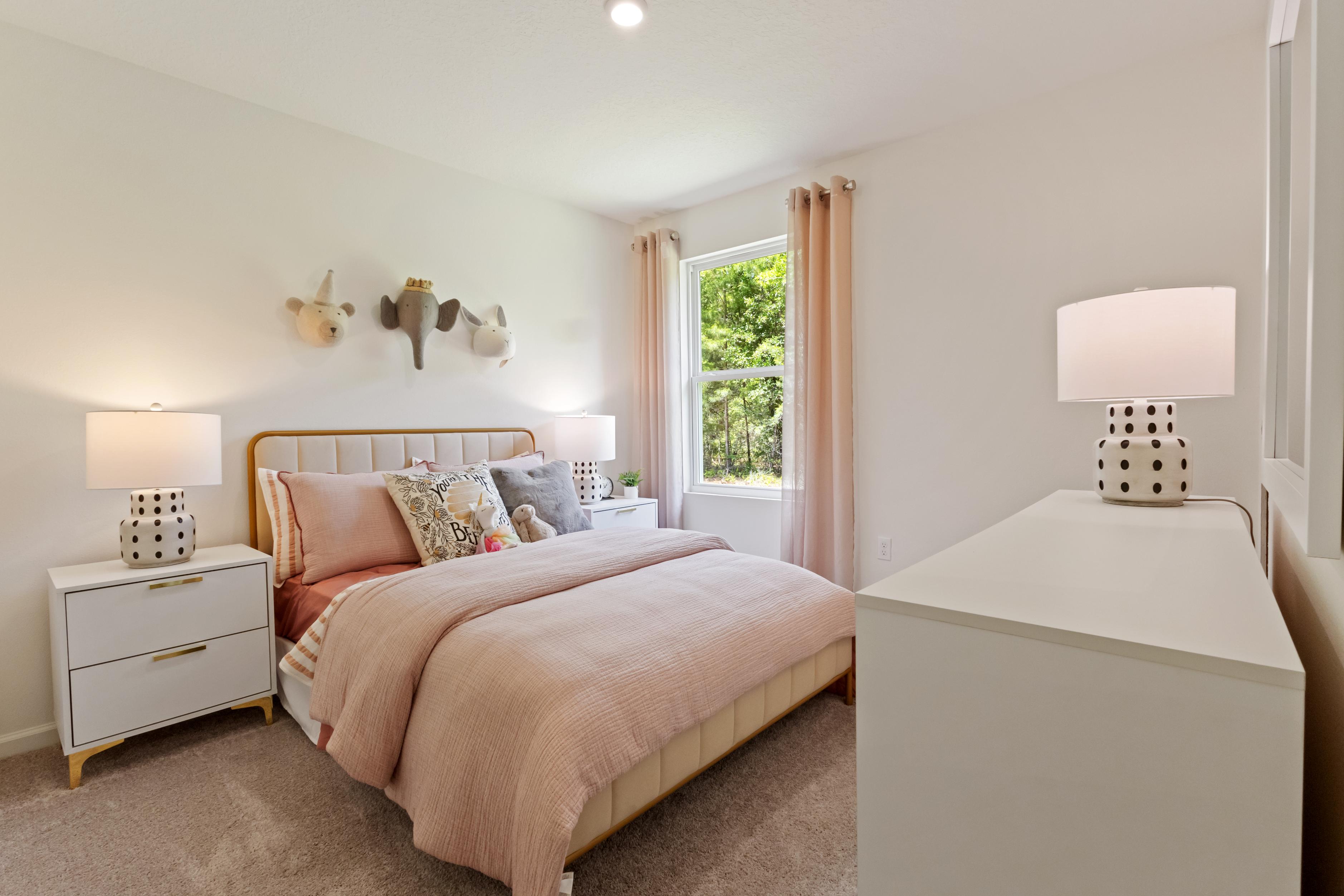 A bedroom with a bed and lamps.