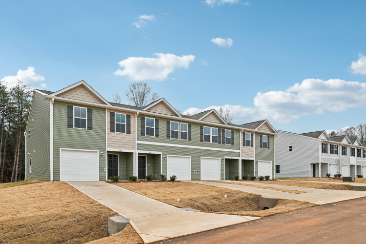A house with garages and a dirt road.